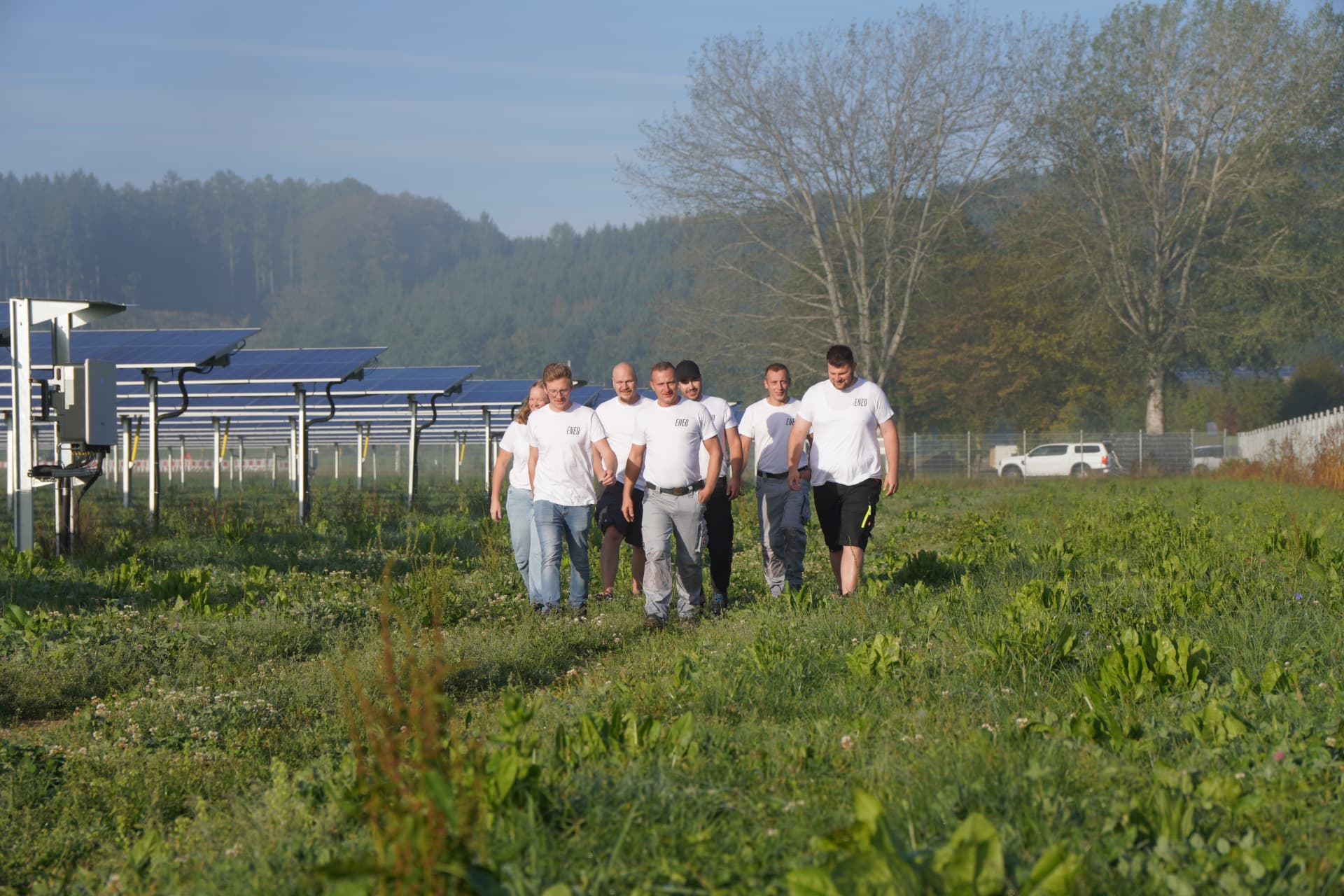 Team von Eneo auf der Wiese einer Agri-PV-Anlage